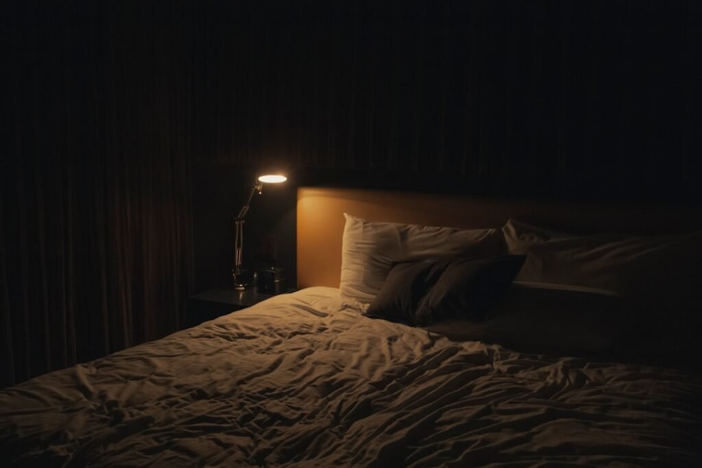 A tidy, minimal bedroom with soft morning light coming through a window onto white bedding