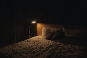 A tidy, minimal bedroom with soft morning light coming through a window onto white bedding