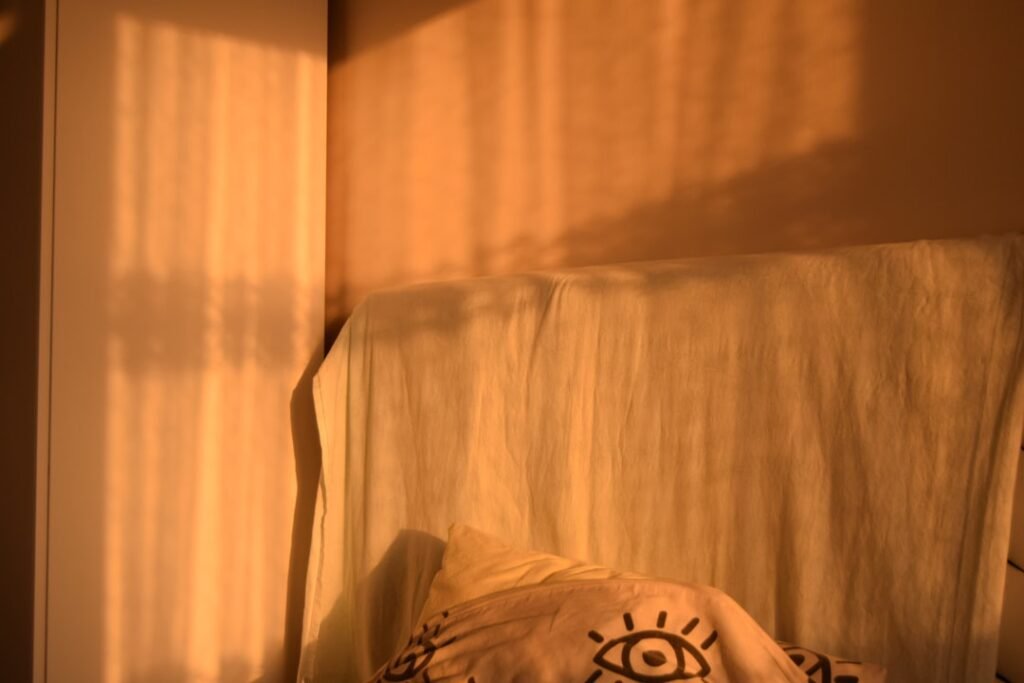 A person resting calmly in bed as soft daylight falls across the pillow and sheets