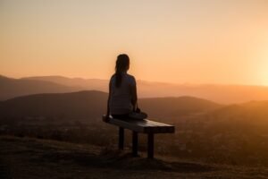 A person sitting cross-legged in quiet meditation in soft natural light