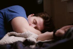 A person asleep in bed with soft natural light coming through a window
