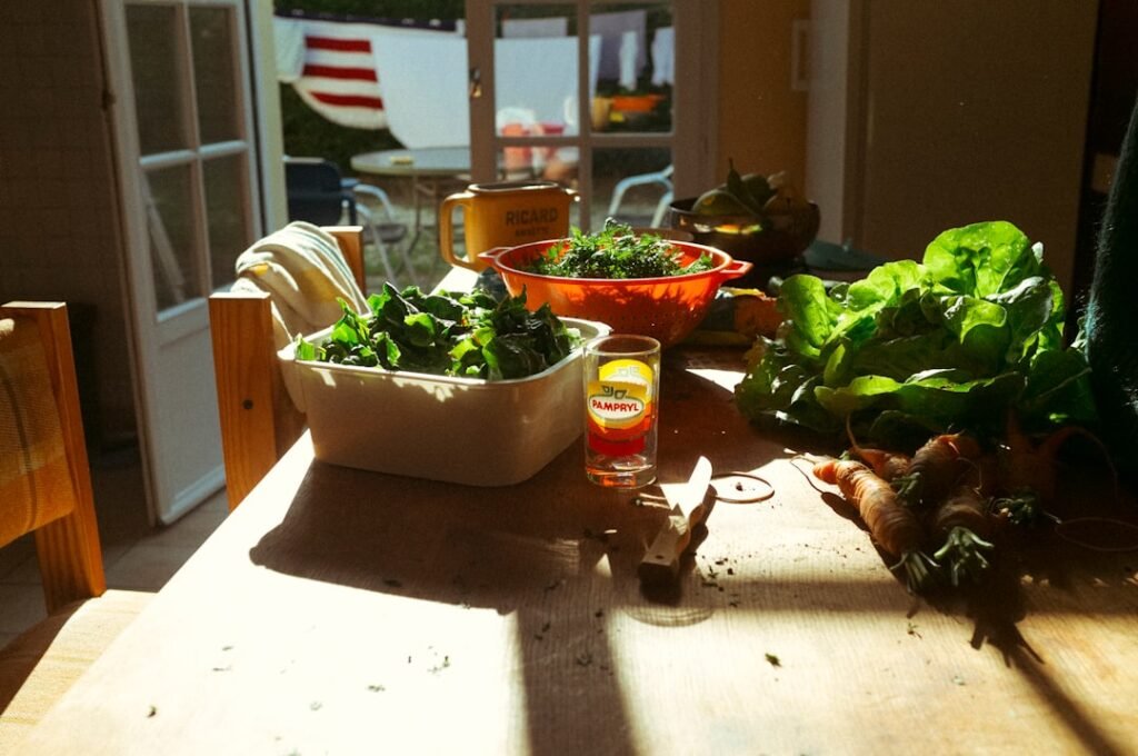 An assortment of fresh vegetables, whole grains, and fruit arranged on a wooden kitchen counter