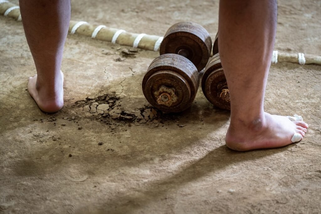 A barbell loaded with heavy weight plates resting on a clean gym floor