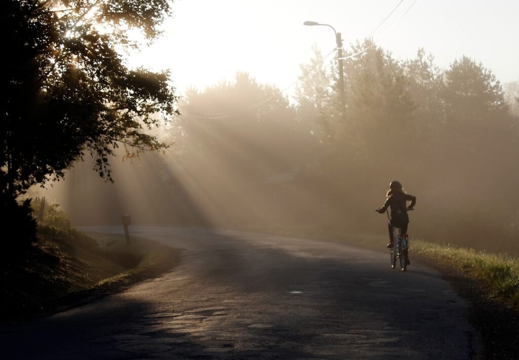 A lone runner training on an open road at dawn, breathing hard during intense effort